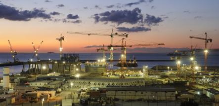 Port de Tanger Med au crépuscule, hub logistique international avec grues, infrastructures industrielles et activité maritime illustrant le dynamisme économique et l’export marocain