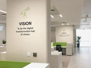 Espace de bureaux moderne avec mur affichant la vision et la mission d’une entreprise spécialisée en transformation digitale