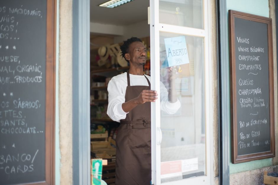 Commerçant installant la nouvelle enseigne de sa boutique avant de modifier sa fiche Google