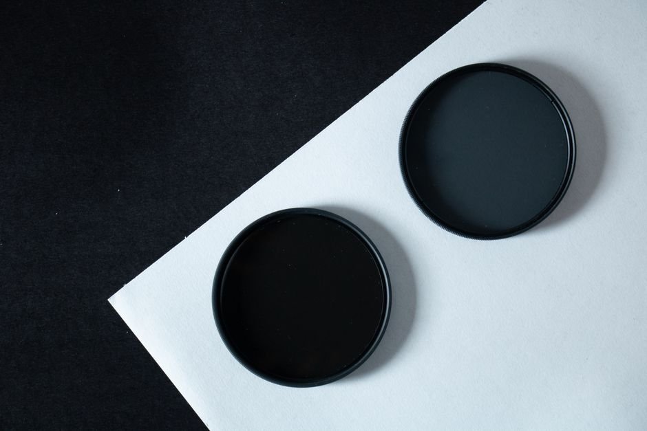 Plusieurs filtres photo ronds posés sur une table, du filtre de protection au polarisant
